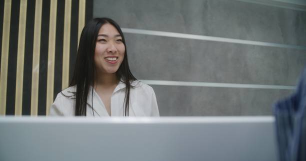 istock Asian female administrator talks with patient on reception 1692169813
