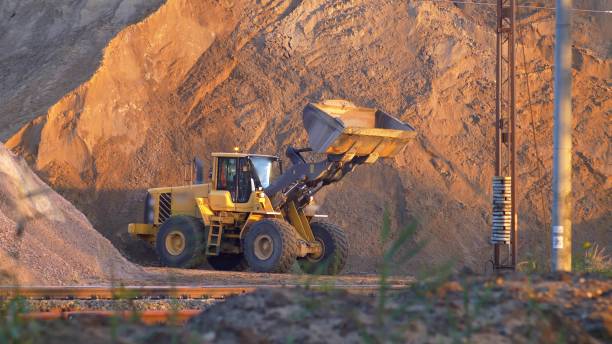 istock Front Loader Next to Huge Heap of Sand on Construction Site 1692176146