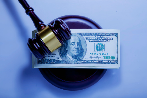 Dollar banknotes and judge's gavel as symbol of corruption in the judicial system