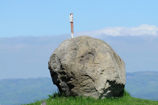 Giant round rock on hill horizon. Geodesy monument.