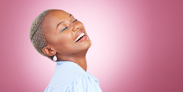 Makeup, laugh and young black woman in a studio with cosmetic, glamour and face routine. Happy, smile and African female model with a cosmetology facial treatment by pink background with mockup space