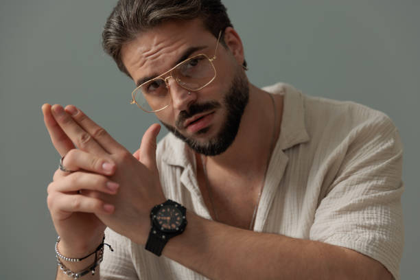 istock casual young man with glasses holding palms together and looking forward 1692210372