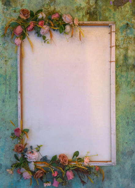 Empty wooden frame with flowers and dry leaves on blue