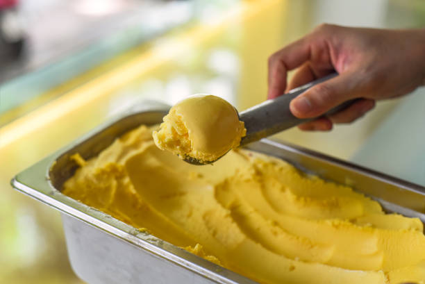 istock hand scooping a scoop of Passion fruit ice cream into a spoon in fridge 1692216924
