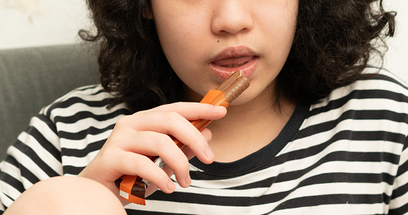 young woman in teenage eat chocolate flavor bar,close up
