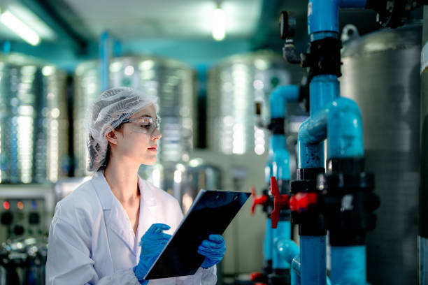 istock scientist worker checking the quality of Reverse osmosis machine system at the industrial factory. Female worker recording data at the control panel with measure pressure for recycle portable plant. 1692218190