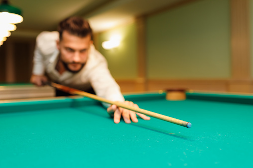 Billiard player aiming at billard table or snooker american billiards pool sport game