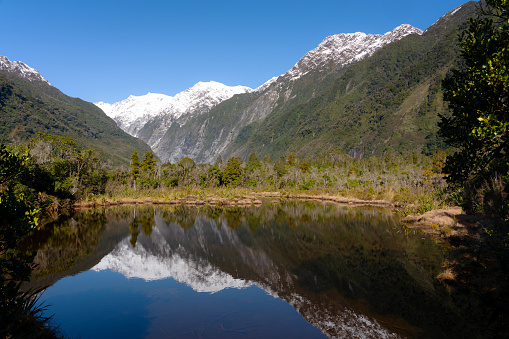 Looking across Peters Pool on New Zealand's South Island towards the Southern Alps and the Franz Josef glacier.