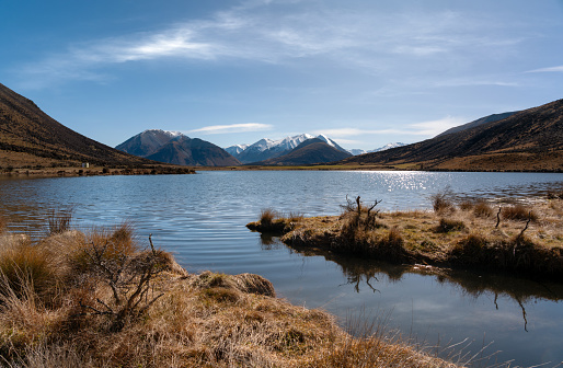 The sun shines down on a small lake in New Zealand’s Southern Alps
