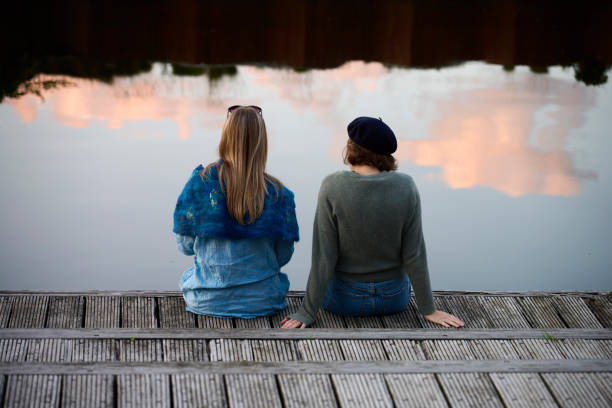 istock Two women sitting on edge of jetty 1692234988