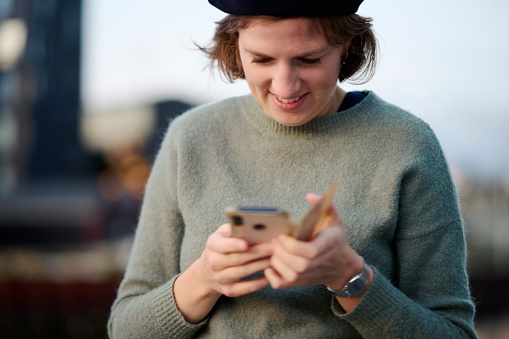 Young adult woman using cell-phone. Selective focus on woman