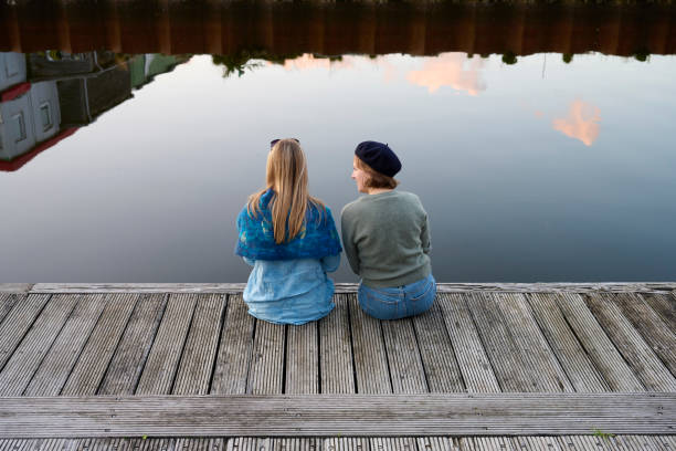 istock Two women sitting on edge of jetty 1692236535