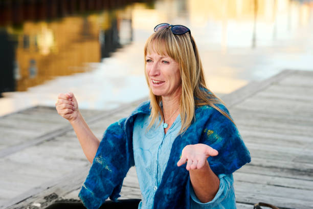 istock Woman sitting on blanket at waterfront 1692244391