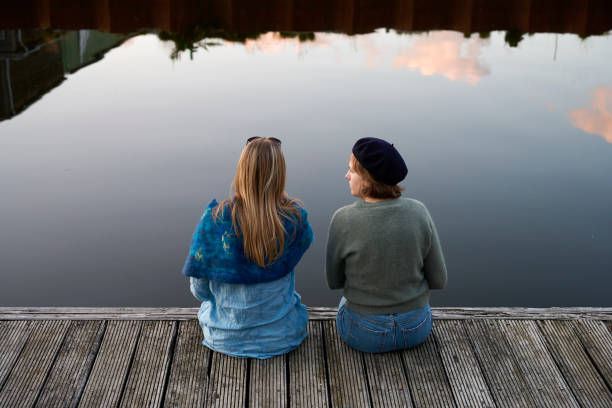 istock Two women sitting on edge of jetty 1692246864