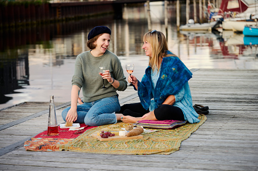 Two adult women having a nice time sharing some wine and food