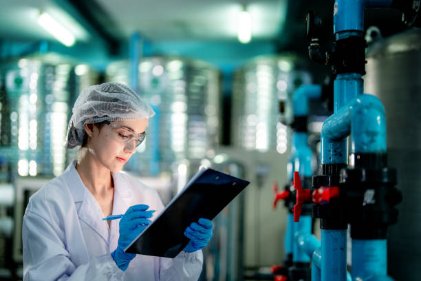 istock scientist worker checking the quality of Reverse osmosis machine system at the industrial factory. Female worker recording data at the control panel with measure pressure for recycle portable plant. 1692250857