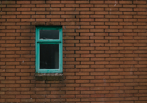 A green window on a brick wall background