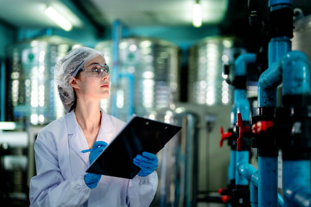 istock scientist worker checking the quality of Reverse osmosis machine system at the industrial factory. Female worker recording data at the control panel with measure pressure for recycle portable plant. 1692270772