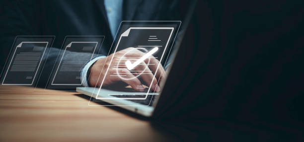 istock Businessman using laptop computer and touching to online electronic paper for approve ISO quality document control certification and project approval concept. 1692271170