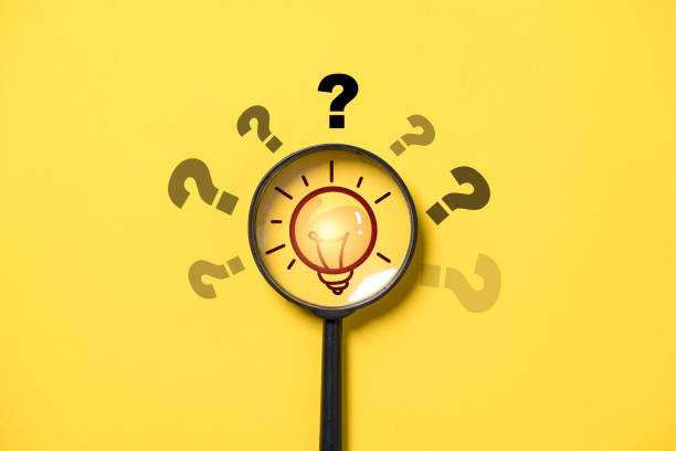 istock Glowing lightbulb inside of black magnifier glass and question mark for focus and concentrate of problem solving ,solution and innovation concept. 1692272313