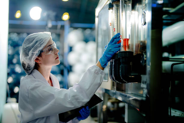 istock scientist worker checking the quality of Reverse osmosis machine system at the industrial factory. Female worker recording data at the control panel with measure pressure for recycle portable plant. 1692276333
