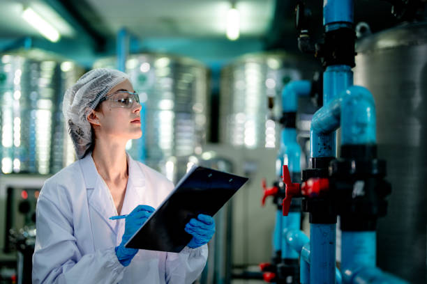 istock scientist worker checking the quality of Reverse osmosis machine system at the industrial factory. Female worker recording data at the control panel with measure pressure for recycle portable plant. 1692282028