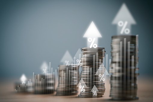 Heap of coins money with up arrow and percentage symbol for financial banking increase interest rate or mortgage investment dividend from business growth concept.