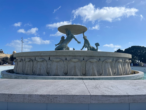 Triton fountain with cloudy sky, downtown Valletta, Malta.