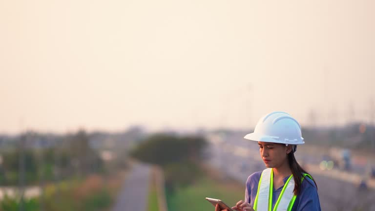 Female civil Engineering working with tablet on bridge highway.