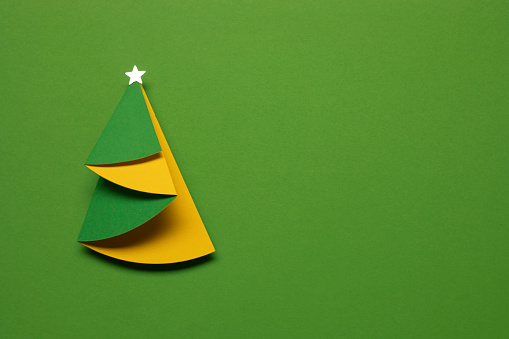 Paper Christmas tree on green.