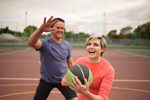 istock Couple casually playing basketball having fun 1692316160