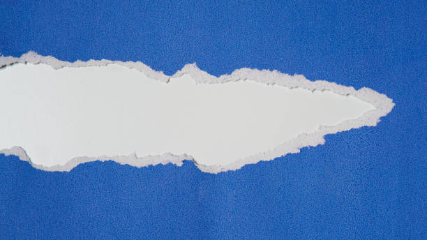 istock Torn blue paper sheet isolated on white background 1692317170