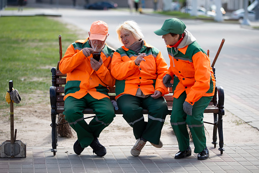 May 08, 2023. Belarus. Avitut village. A group of janitors are sitting on a bench. City cleaners.
