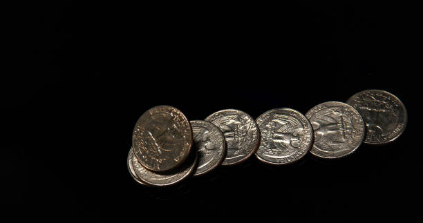 istock Quarter Dollar Coins Falling, Rolling and Sliding on Black Background 1692346949