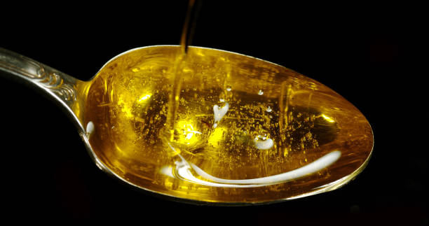 istock Olive Oil, Falling in a Spoon against Black Background 1692359676