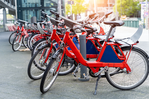 Closeup view many red city bikes parked in row at german Hamburg city street rental parking sharing station or sale. Healthy ecology urban transportation. Sport environmental transport infrastructure.