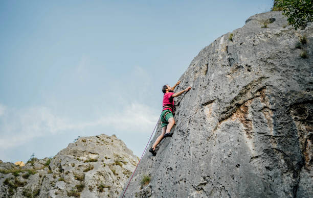 istock Man with a rope climbing on the rock 1692376239