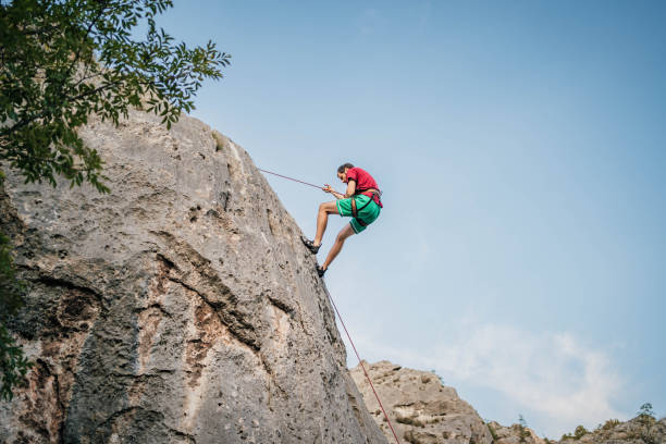 istock Man with a rope climbing on the rock 1692376273
