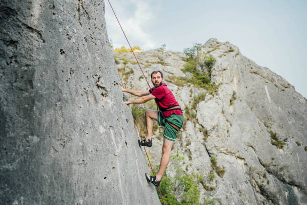 istock Young man conquers a cliff rock wall 1692378464