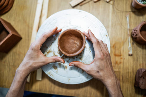 istock Man molding clay on a pottery wheel at the workshop 1692387150