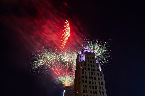 Image of Red and white fireworks lighting up night sky behind Lincoln Tower on 4th of July