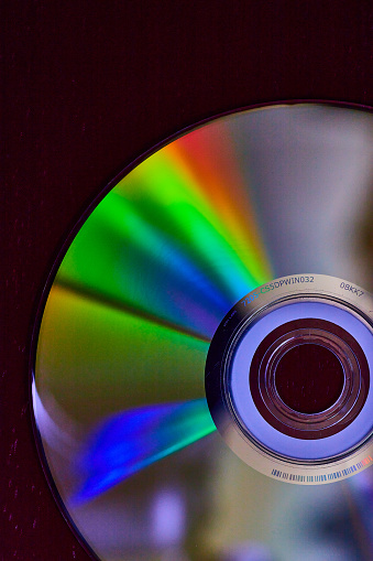 CD DVD compact optical disk storage medium with dust and scratches. Rainbow spectrum of iridescent colors
