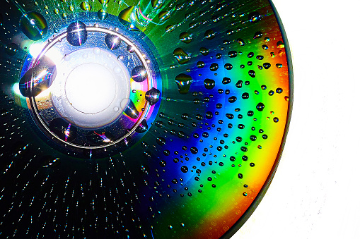 Image of Stunning water drops on dark CD surface with white background abstract asset art