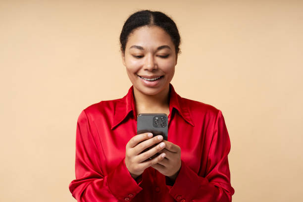 istock Smiling African American business woman using mobile phone reading text message 1692402747