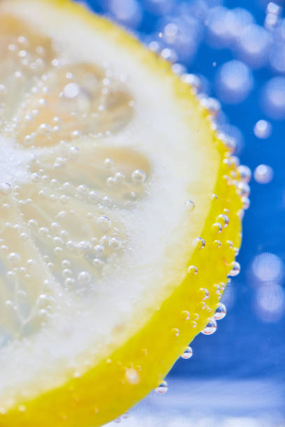 istock Yellow lemon slice with silvery bubbles and blue background 1692403415