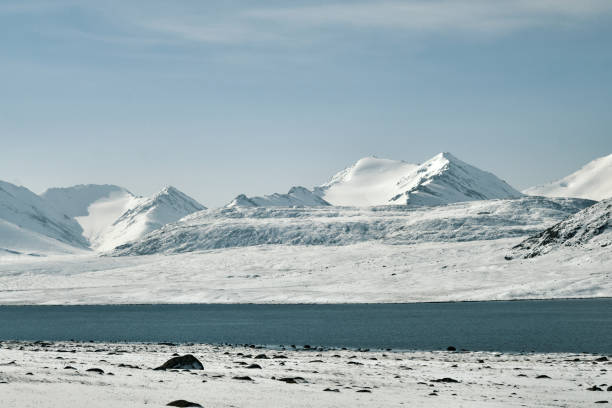 Mountain lake on highland valley covered by snow
