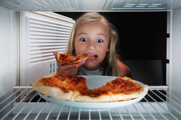 istock hungry girl eating pizza from fridge 1692415599