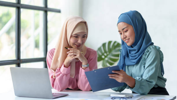istock Team work process Two Muslim business women pointing at a laptop computer and discussing document and ideas at a meeting. 1692418602