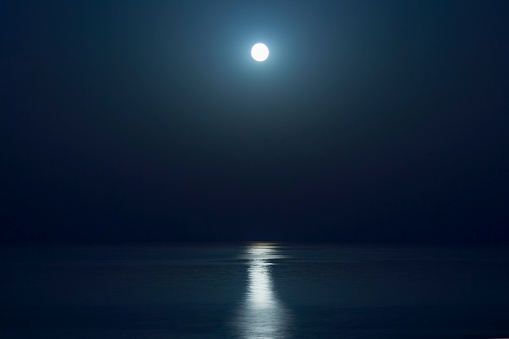 Fantastic blue sea background. Mediterranean Sea at night. Moon reflecting in a sea