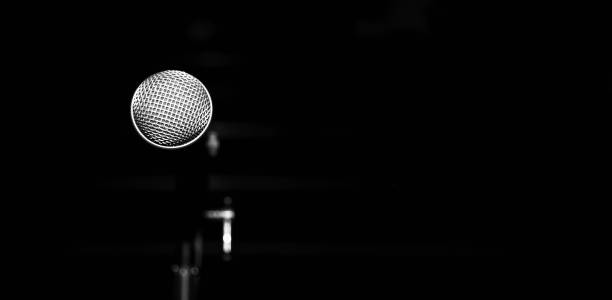 istock Public performance on stage microphone on stage against blured  background of concert hall. Black and white photo. 1692429143